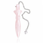 Pendule de Thot en quartz rose pastel sculpté, couché de profil sur fond blanc neutre avec sa chaînette métallique et sa perle en cristal.