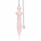 Pendule Thot en pierre naturelle de quartz rose suspendu verticalement par sa chaînette argentée sur fond blanc.