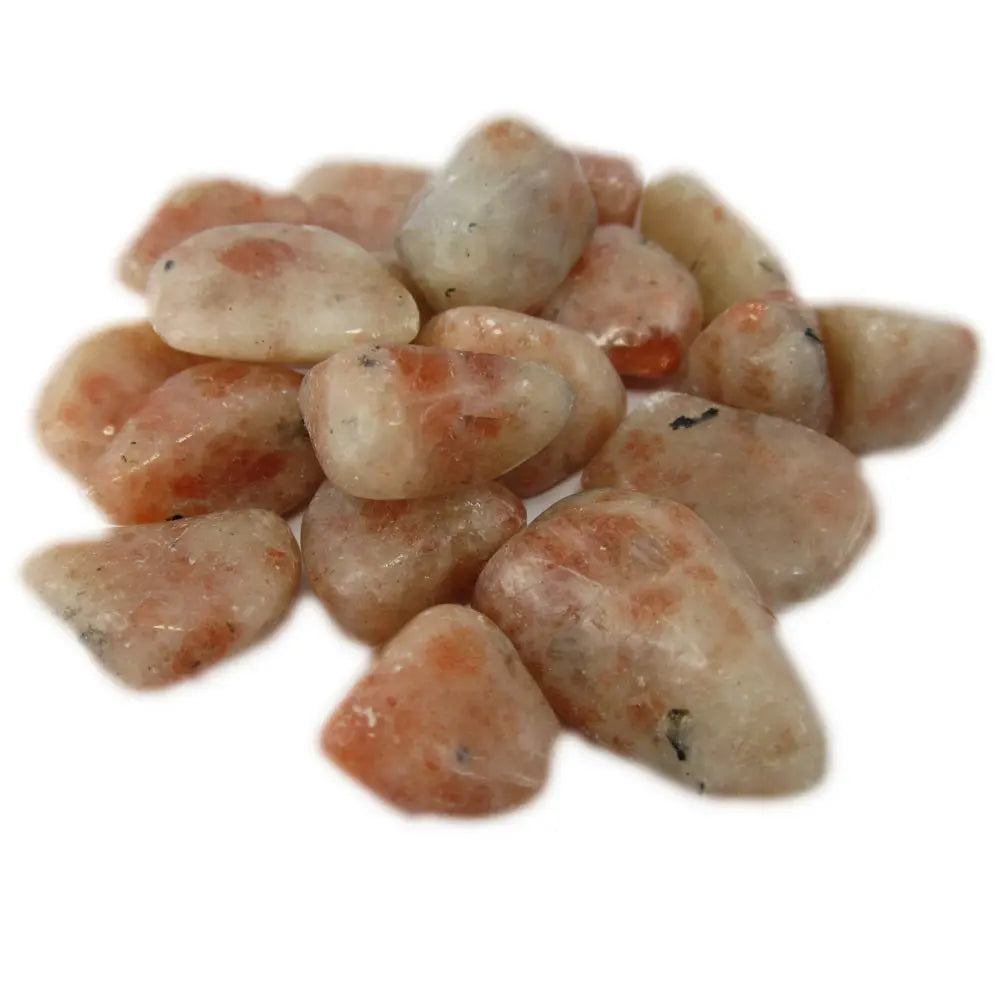 Un groupe de pierres de pierre de soleil roulées aux teintes crème et orangées parsemées de paillettes scintillantes naturelles, présenté sur un fond blanc uni.