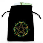 Pochette en velours noir à cordons, brodée d’un pentagramme doré entouré de feuilles vertes (cartes visibles).