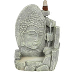 Porte-encens backflow gris aspect pierre, visage de Bouddha et cascade de fumée, cône d’encens placé en haut, sur fond blanc.