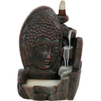 Porte-encens backflow noir effet pierre avec visage de Bouddha, cascade de fumée blanche et cône d’encens au sommet, sur fond blanc.