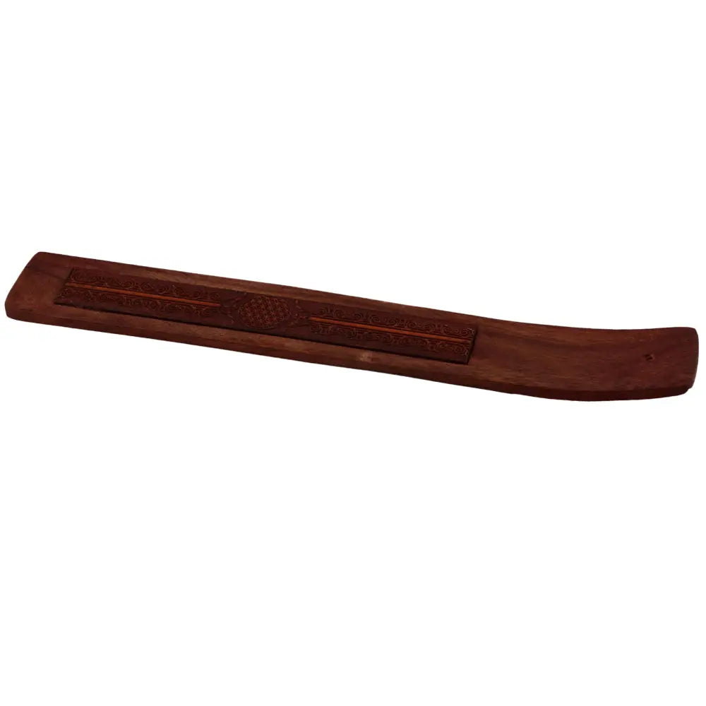 Porte-encens en bois allongé et légèrement courbé, gravé de motifs décoratifs avec un médaillon central « fleur de vie », sur fond blanc.