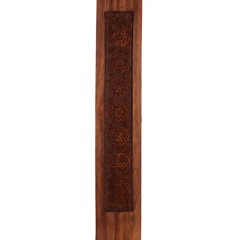 Gros plan vertical d’un porte-encens en bois gravé avec les symboles des 7 chakras alignés, sur fond blanc.