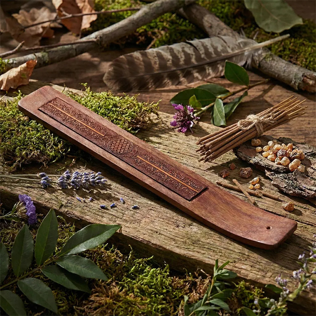 Porte encens en bois de Sheesham Gravé - Fleur de Vie posé sur une table pour brûler un bâtonnet.