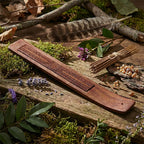 Porte encens en bois de Sheesham Gravé - Fleur de Vie posé sur une table pour brûler un bâtonnet.
