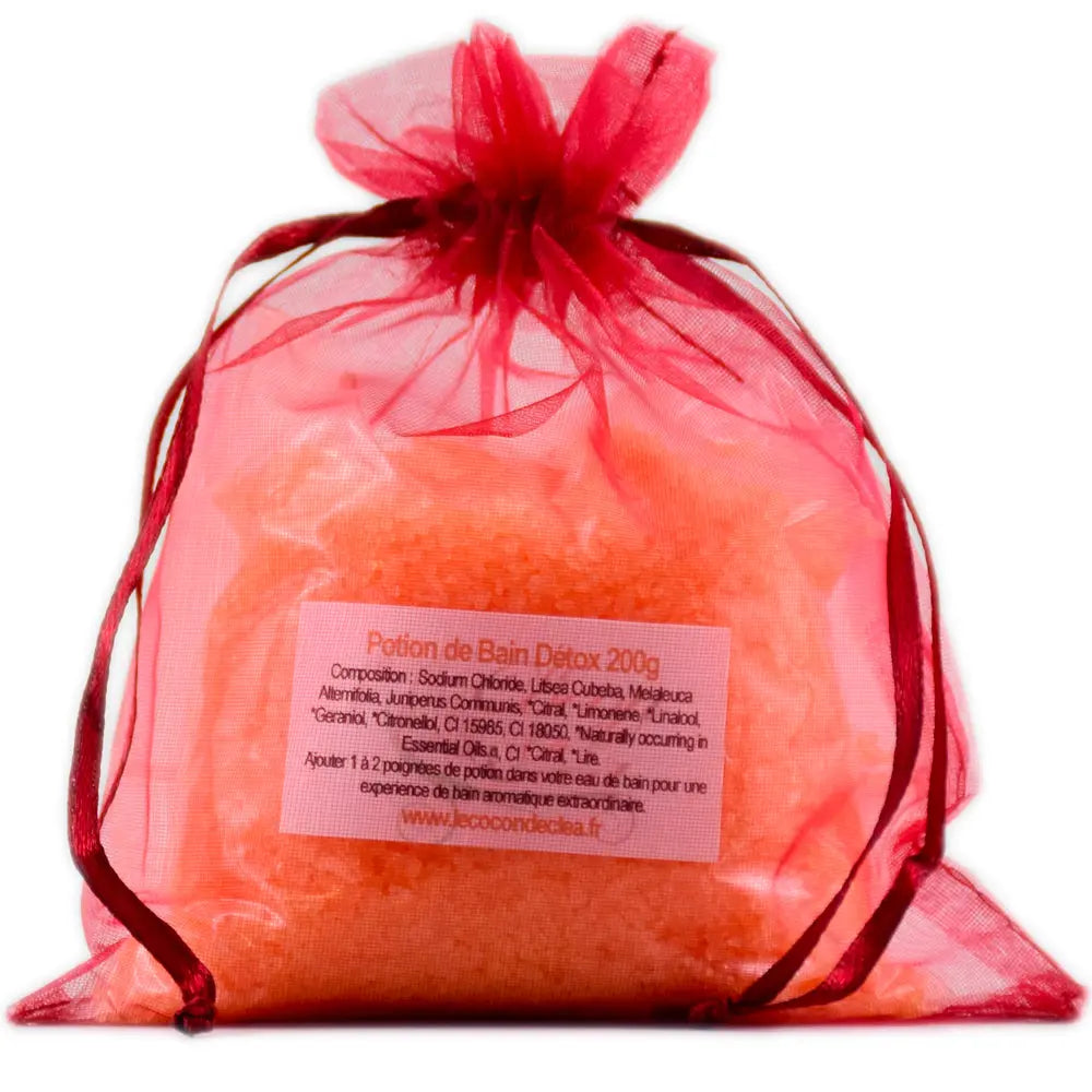 Sachet en organza rouge orangé rempli de sels de la Potion de bain Détox sur fond blanc.