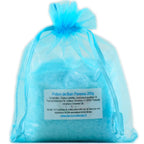 Sachet en organza bleu turquoise rempli de sels de la Potion de bain Paresse sur fond blanc