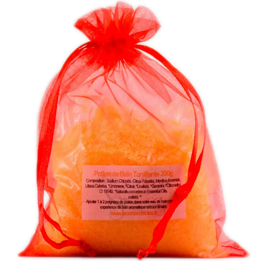 Sachet en organza orange vif rempli de sels de la Potion de bain Tonifiante sur fond blanc.