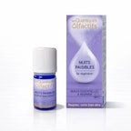 Un flacon de complexe d'huiles essentielles bio "Nuits Paisibles" de la gamme Les Quantiques Olfactifs, accompagné de son étui violet, présenté avec son reflet sur un fond blanc.