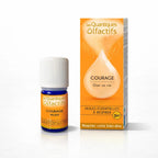 Un flacon de complexe d'huiles essentielles bio "Courage" de la gamme Les Quantiques Olfactifs, accompagné de son étui orange, présenté avec son reflet sur un fond blanc.