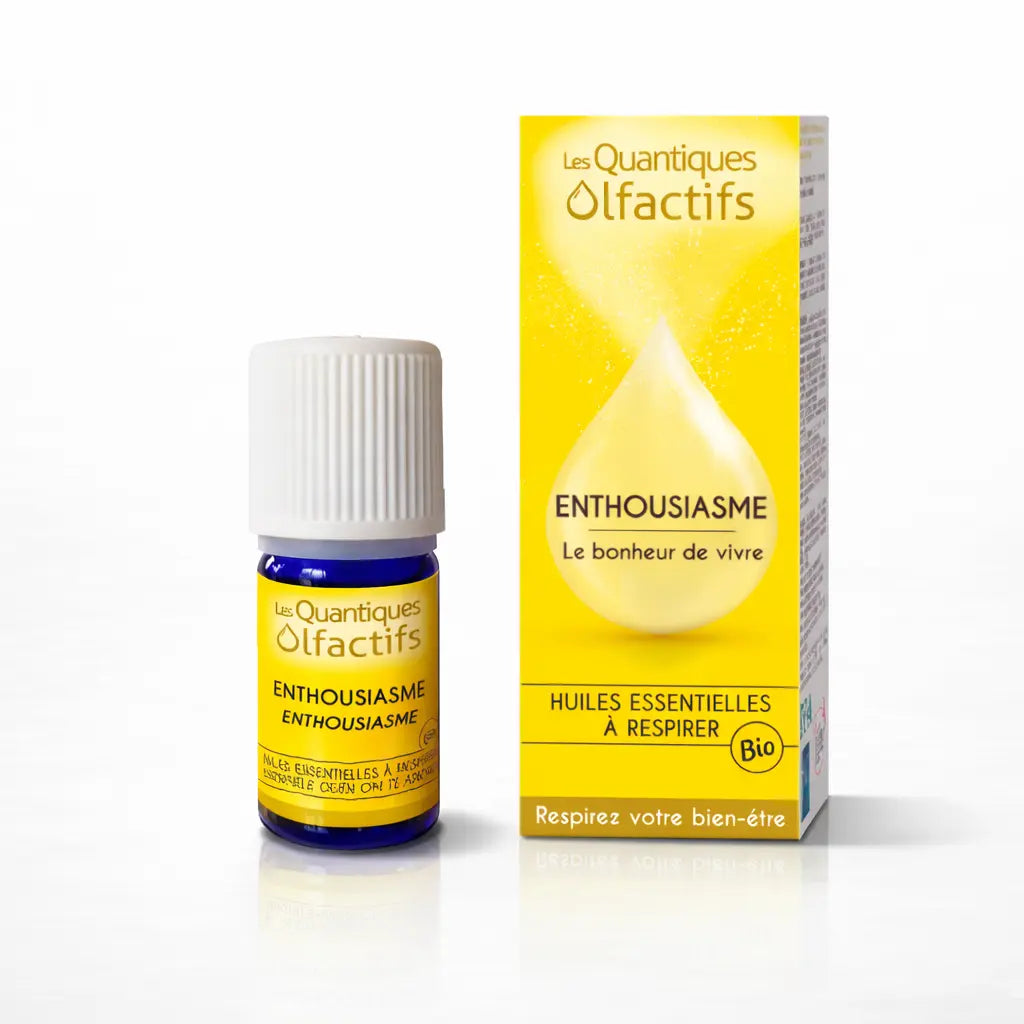 Un flacon de complexe d'huiles essentielles bio "Enthousiasme" de la gamme Les Quantiques Olfactifs, accompagné de son étui jaune, présenté avec son reflet sur un fond blanc