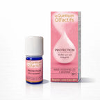 Un flacon de complexe d'huiles essentielles bio "Protection" de la gamme Les Quantiques Olfactifs, accompagné de son étui de couleur vieux rose, présenté avec son reflet sur un fond blanc.