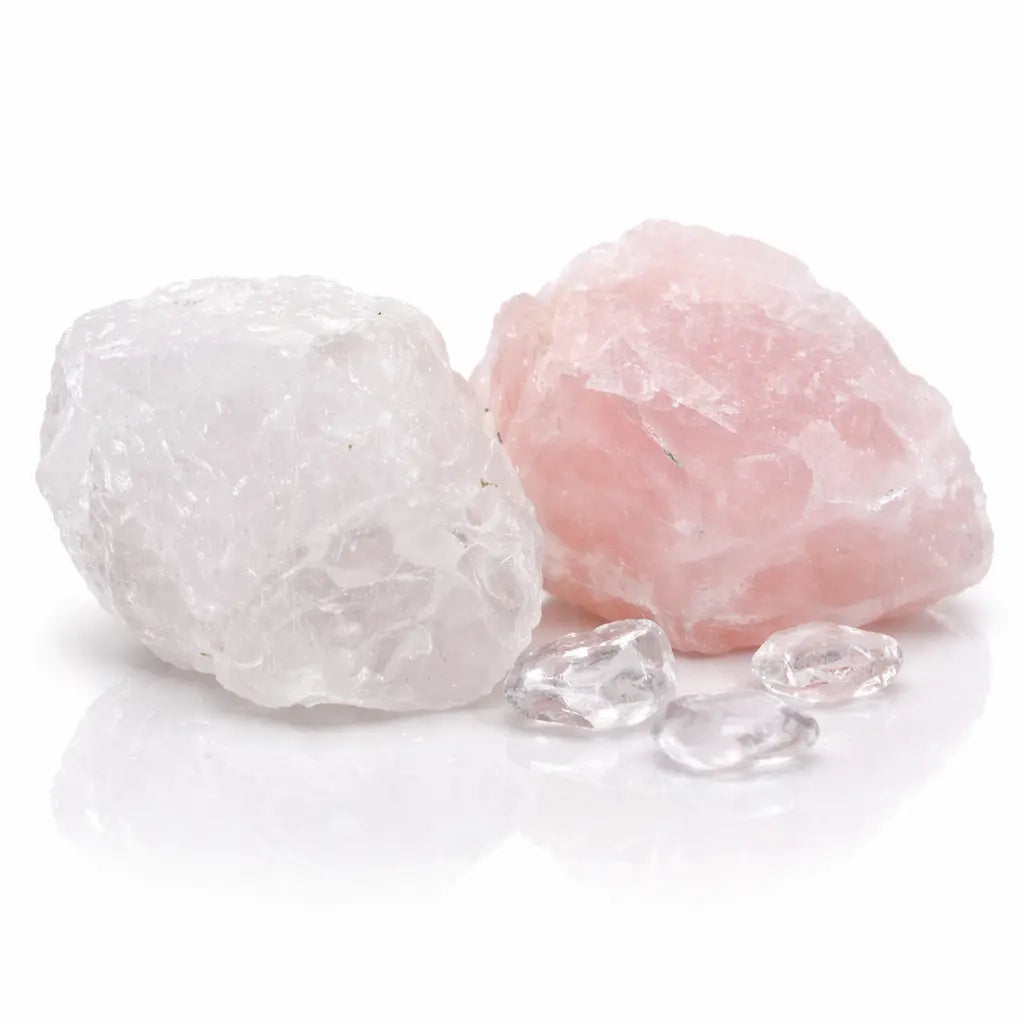 Deux blocs de quartz rose brut aux textures irrégulières, l'un d'un rose pâle et l'autre plus blanc, accompagnés de petits éclats transparents et présentés sur un fond blanc avec des reflets.