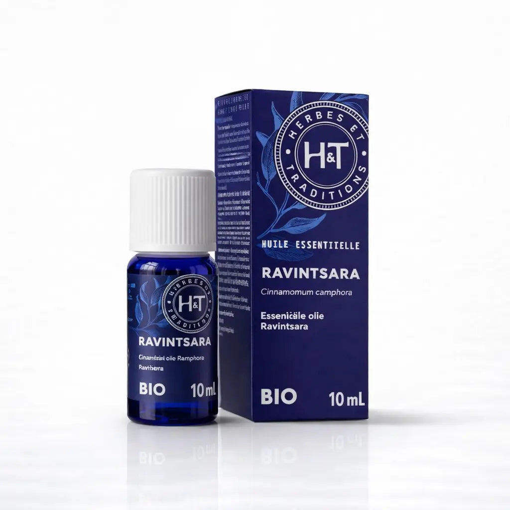 Un flacon de 10 ml d'huile essentielle de ravintsara bio de la marque Herbes & Traditions, accompagné de son étui en carton bleu foncé assorti, présenté sur un fond blanc.