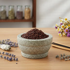 Grains d'encens de résine Roi Mage N°1 (brun foncé/bordeaux) dans un mortier en granit gris, entouré de bouquets de lavande et de sauge blanche.