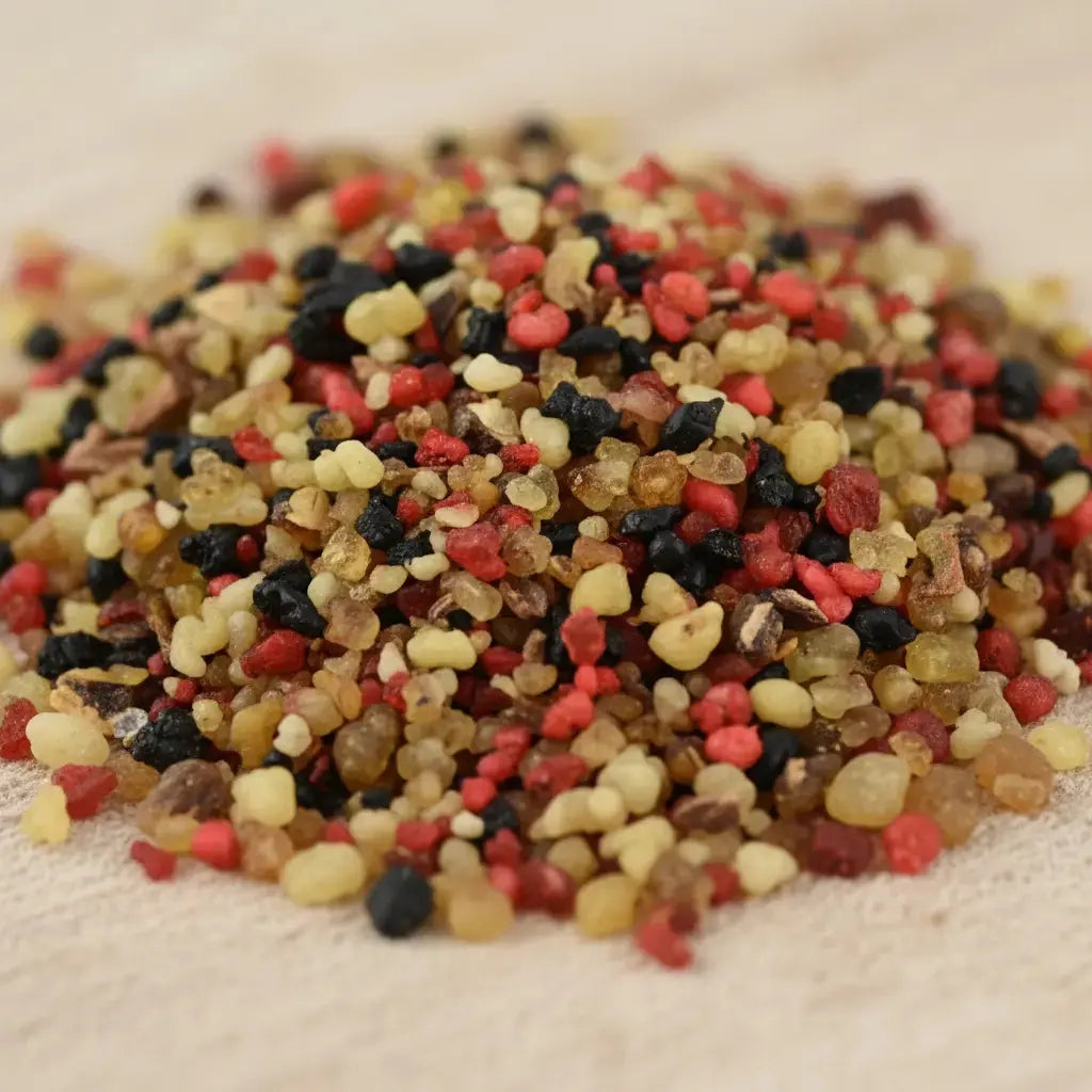 Gros plan sur un monticule de grains d'encens de résine Roi Mage N°3, montrant un mélange dense de jaune pâle/ambre, de rouge carmin et de noir.