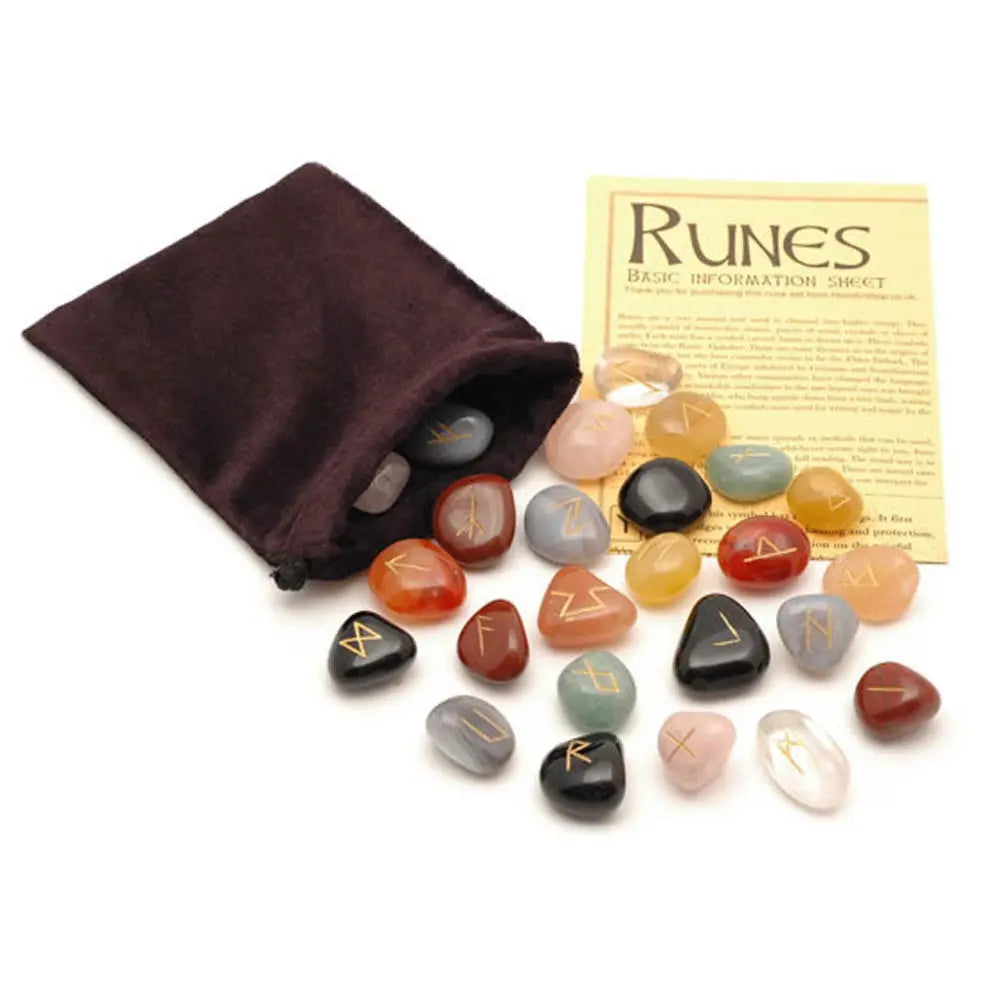 Set de runes en pierres roulées multicolores gravées dorées, avec pochette en velours marron et fiche d’information sur les runes.