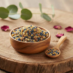 Grains d'encens de résine Saint Joseph, mélange de billes bleues et ocres, dans un bol en bois posé sur une tranche de tronc d'arbre, avec une cuillère.