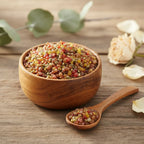 Coupelle en bois remplie de grains d’encens Saint Uriel multicolores avec petite cuillère sur table en bois, décorée de pétales de fleurs.
