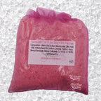Sachet en organza rose rempli de Sel de bain framboise artisanal 200g sur un fond de cristaux blancs.