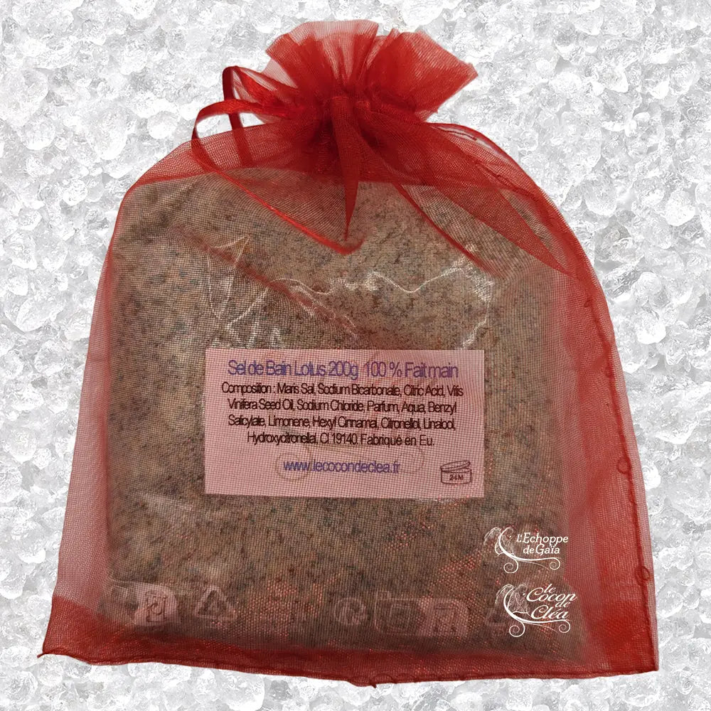 Sachet en organza rouge rempli de Sel de bain lotus artisanal 200g sur un fond de cristaux blancs.