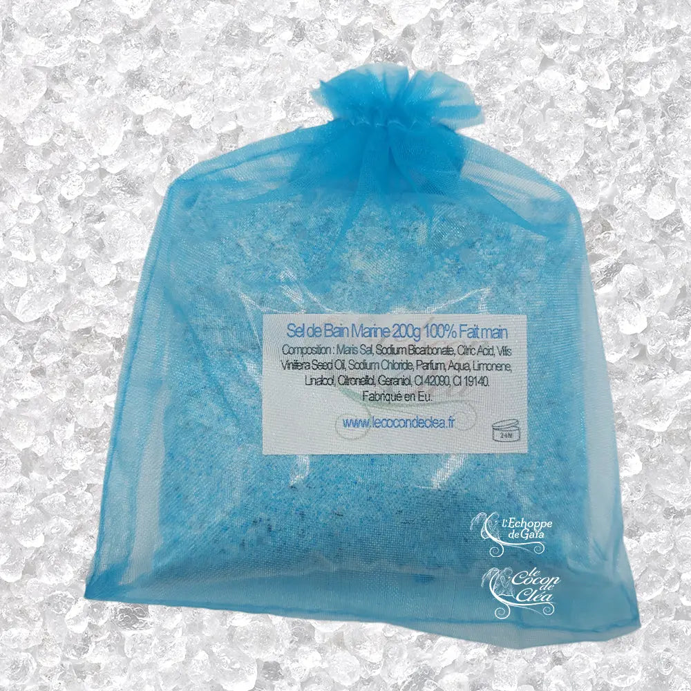 Sachet en organza violet rempli de Sel de bain patchouli artisanal 200g sur un fond de cristaux blancs.