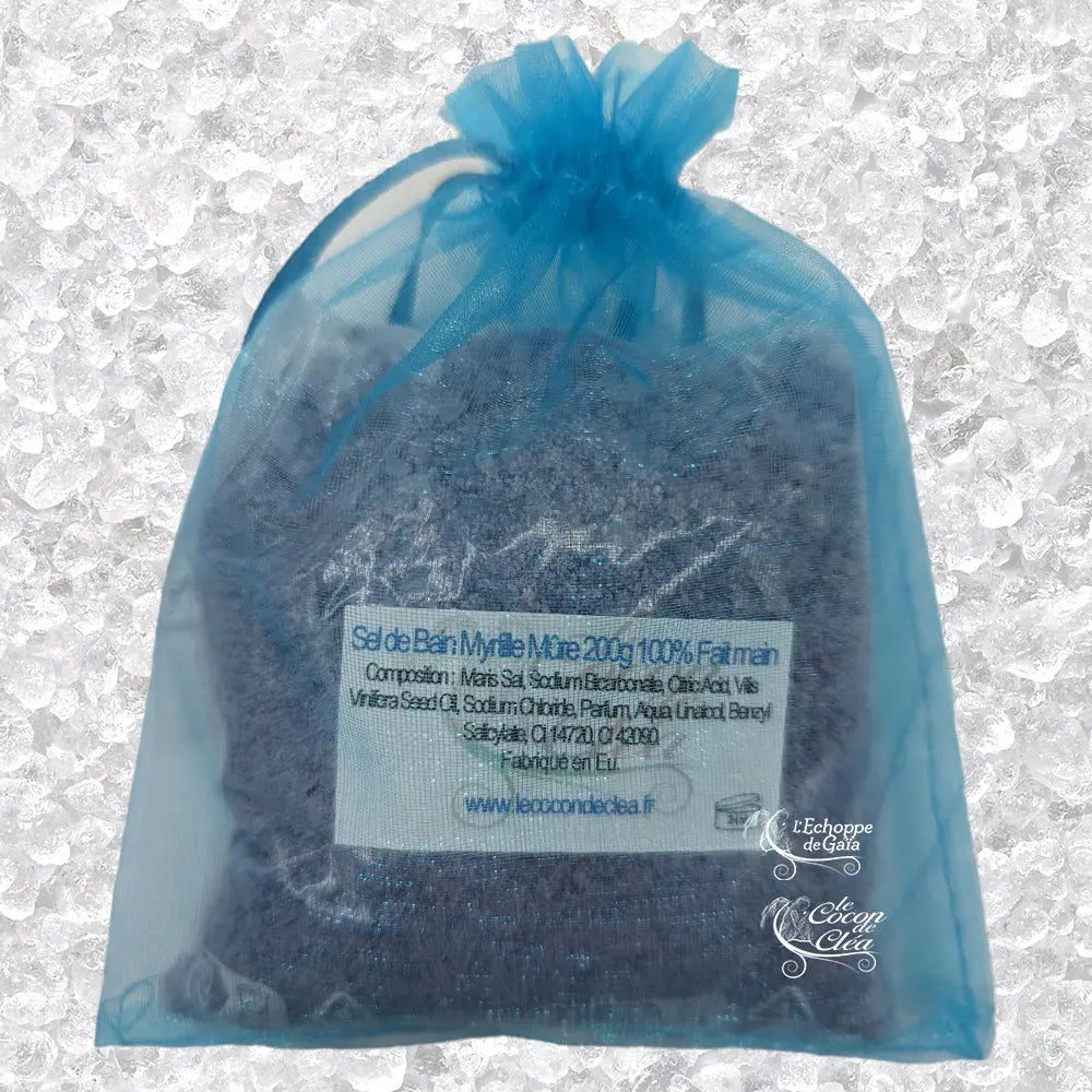 Sachet en organza bleu rempli de Sel de bain myrtille mûre artisanal 200g sur un fond de cristaux blancs.