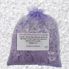 Sachet en organza violet rempli de Sel de bain patchouli artisanal 200g sur un fond de cristaux blancs.