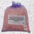 Sachet en organza mauve rempli de Sel de bain rose artisanal 200g sur un fond de cristaux blancs.