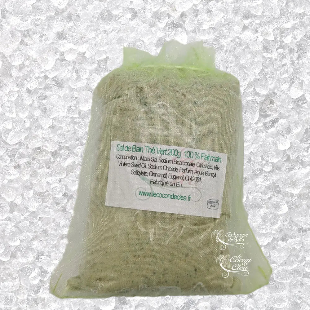 Sachet en organza vert rempli de Sel de bain thé vert artisanal 200g sur un fond de cristaux blancs.