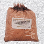 Sachet en organza marron rempli de Sel de bain vanille artisanal 200g sur un fond de cristaux blancs.
