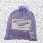 Sachet en organza mauve rempli de Sel de bain violette artisanal 200g sur un fond de cristaux blancs.
