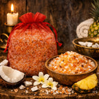 Sels de Bain Pina Colada orange dans un bol en bois avec noix de coco, ananas et sachet organza rouge sur bois.
