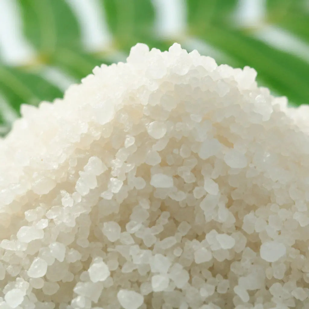 Gros plan sur des cristaux de sel infusé Bonheur des Anges, texture cristalline blanche.