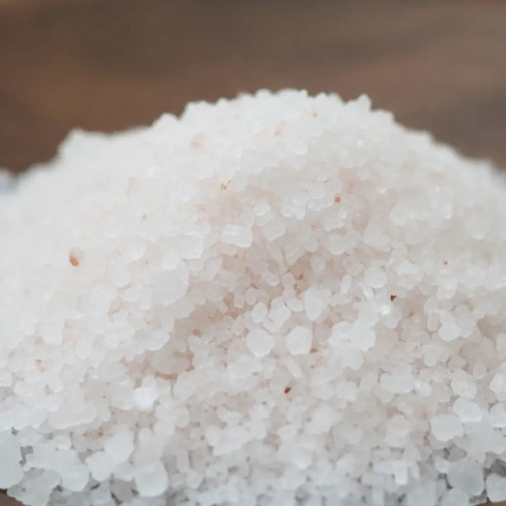 Gros plan sur les cristaux blancs et la texture granuleuse du sel infusé Coconut