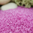 Gros plan sur les cristaux granulés rose fuchsia du sel infusé figue et cassis