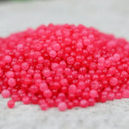 Gros plan sur des cristaux de sel infusé aux Fruits des Bois, texture cristalline rose vif.