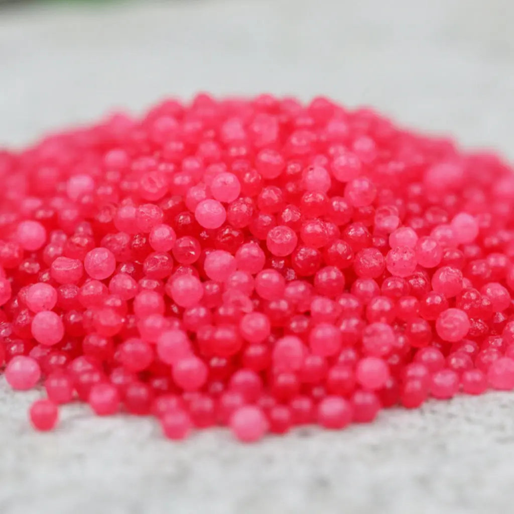 Gros plan sur des cristaux de sel infusé aux Fruits des Bois, texture cristalline rose vif.