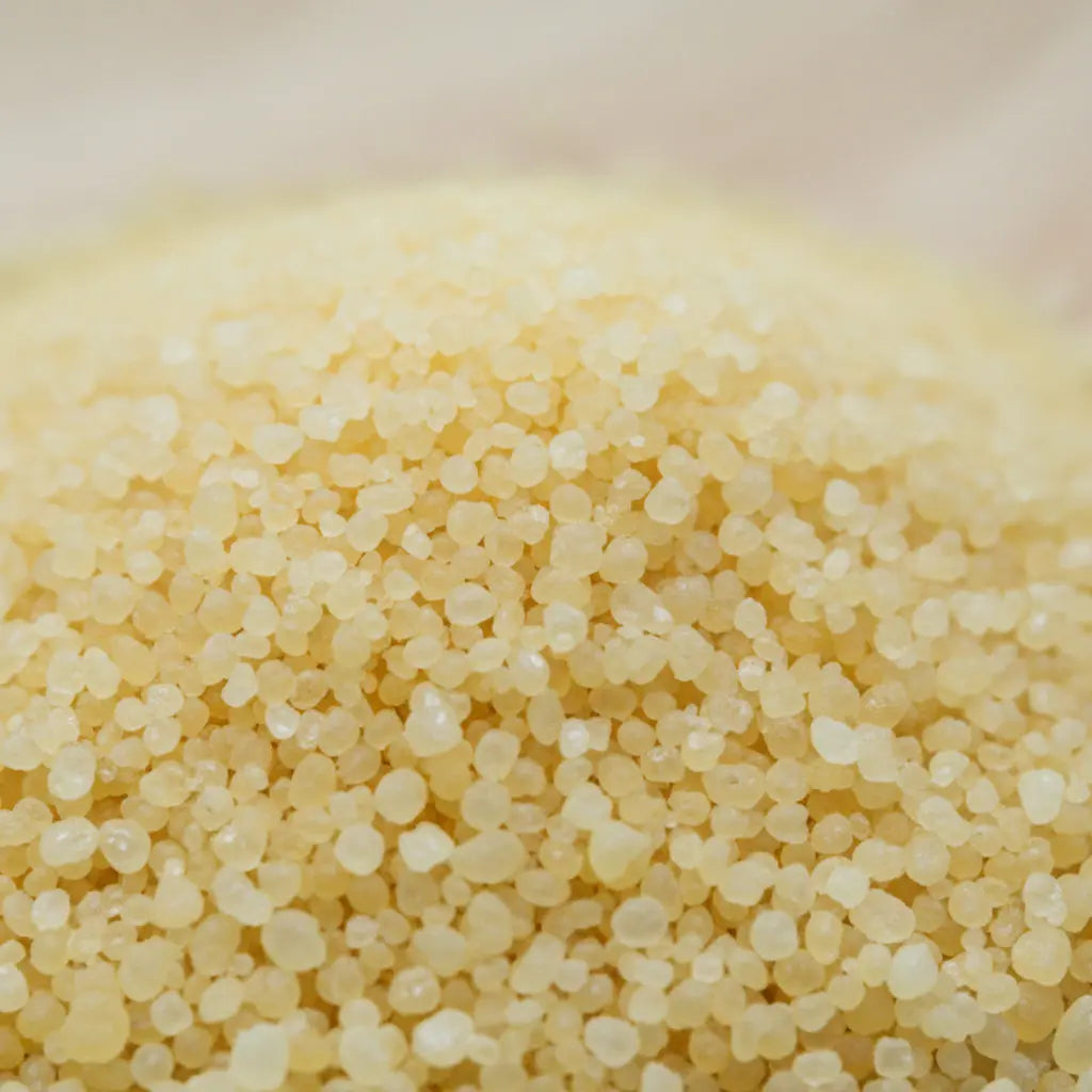Gros plan sur les grains dorés et la texture cristalline du sel infusé.
