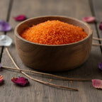 Bol en bois rempli de Granulés Sel Infusé - Patchouli de couleur orange vif pour rituel d'ancrage