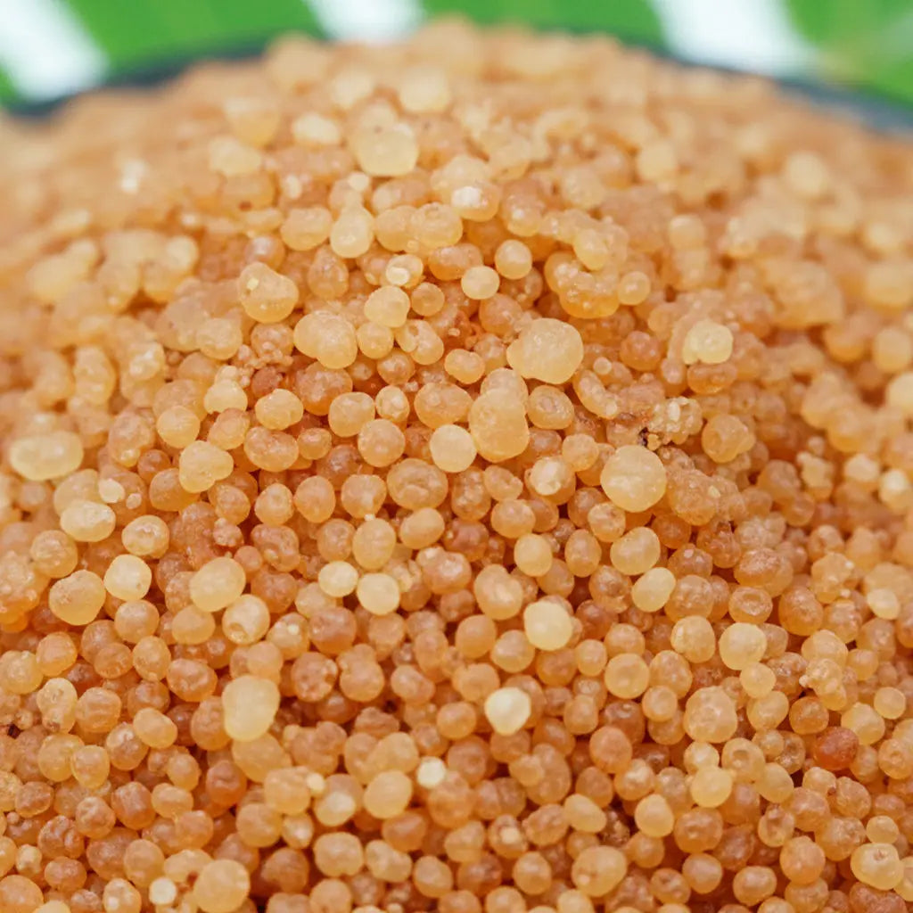 Gros plan sur des cristaux de sel infusé au Santal, texture cristalline brun ambré.