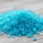 Gros plan sur des cristaux de sel infusé à la Brise Marine, texture cristalline bleue.