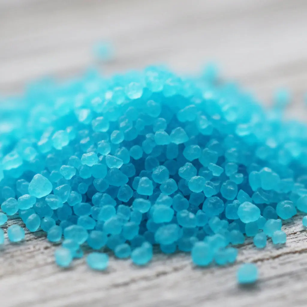 Gros plan sur des cristaux de sel infusé à la Brise Marine, texture cristalline bleue.