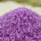 Gros plan sur les cristaux granulés violet intense du sel infusé Violette et Musc