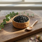 Encens storax en grains noirs dans une coupelle en bois avec petite cuillère sur planche en bois.