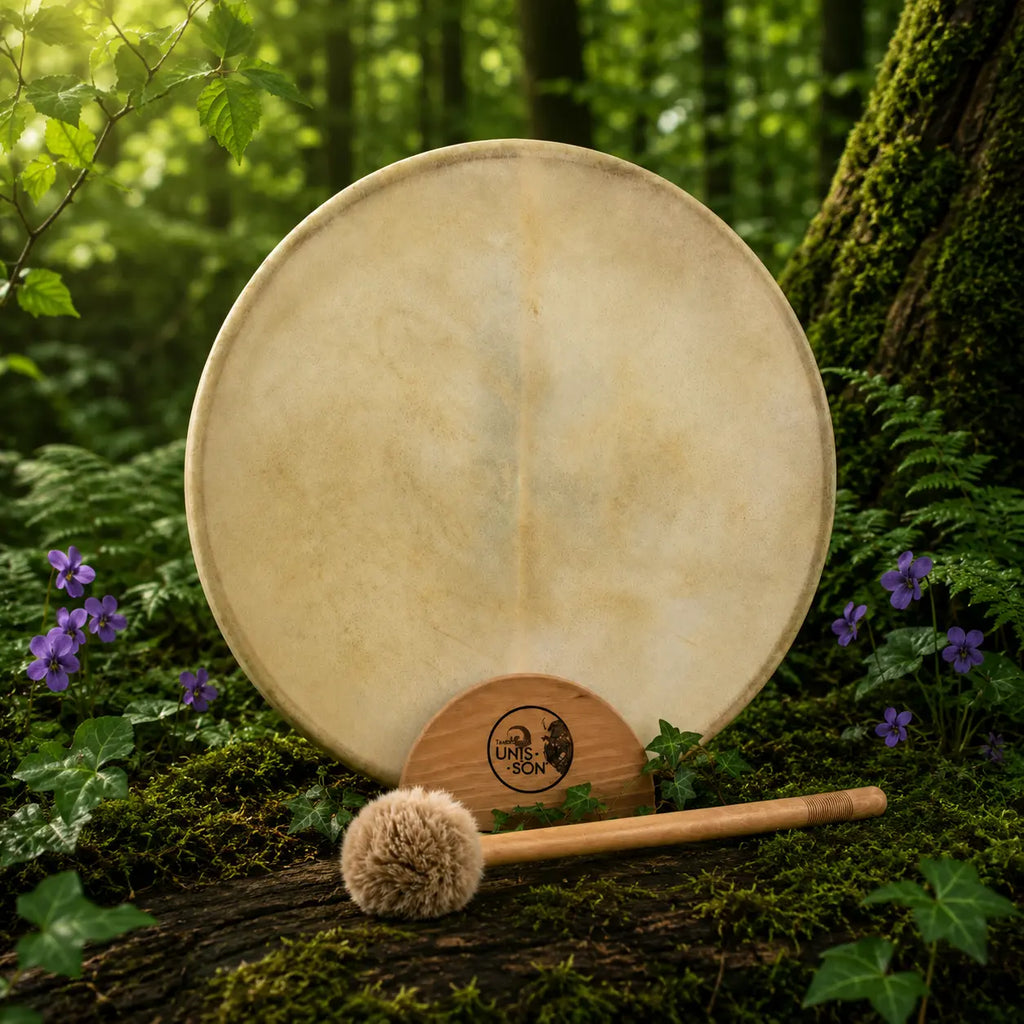 Tambour Unis-Son Luna rond doté d'une membrane claire et épurée aux nuances beige naturel, posé sur un tronc moussue avec sa mailloche en bois de frêne.