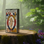 Boîte noire et blanche traditionnelle du Tarot de Marseille Grimaud posée sur une souche, illustrée de l'arcane XXI Le Monde entouré des quatre vivants.
