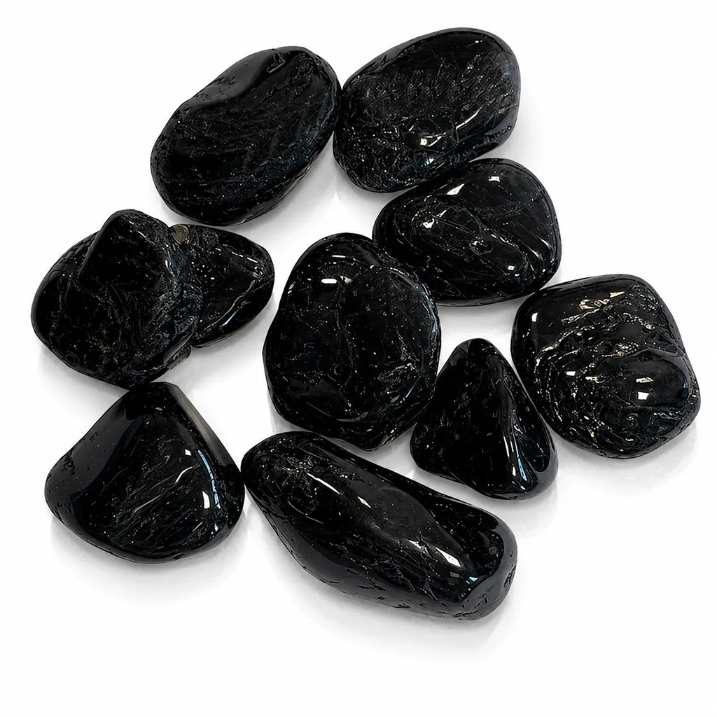 Lot de pierres roulées en tourmaline noire aux surfaces lisses et brillantes sur fond blanc.