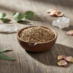 Racines de valériane coupées pour fumigation, présentées en petits bâtonnets brun clair dans une coupelle en bois sombre posée sur une table en bois brut, décorée de pétales de rose, de cristaux translucides et de feuilles d’eucalyptus dans une lumière douce et naturelle.